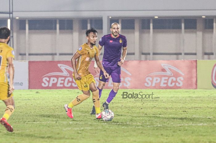 Gelandang Bhayangkara FC, Muhamad Hargianto (kiri), sedang menguasai bola dan dibayangi striker Persik Kediri, Youssef Ezzejjari (kanan), dalam laga pekan kelima Liga 1 2021 di Stadion Madya, Senayan, Jakarta, 29 September 2021.