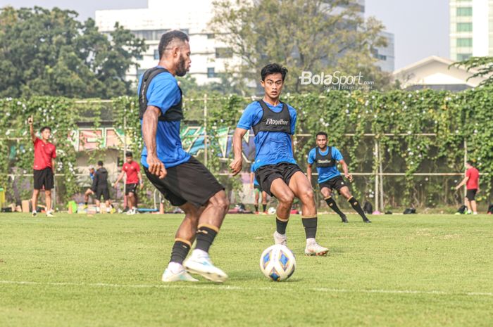 Pemain sayap kiri timnas Indonesia, Yabes Roni (kiri), nampak akan mengirimkan umpan dan coba dihalau oleh Pratama Arhan (kanan),  dalam sesi latihan di Lapangan G (Panahan), Senayan, Jakarta, 2 Oktober 2021.