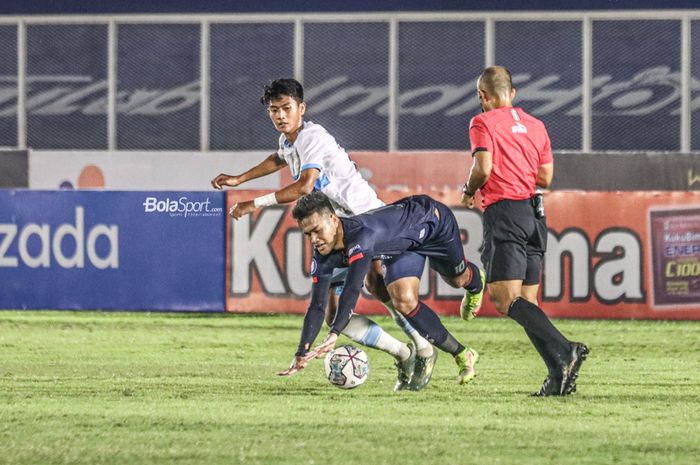 Pemain sayap kanan Persela Lamongan, Malik Risaldi (kiri), nampak menyenggol striker Arema FC, Muhammad Rafli (tengah), dalam laga pekan keenam Liga 1 2021 di Stadion Madya, Senayan, Jakarta, 3 Oktober 2021.