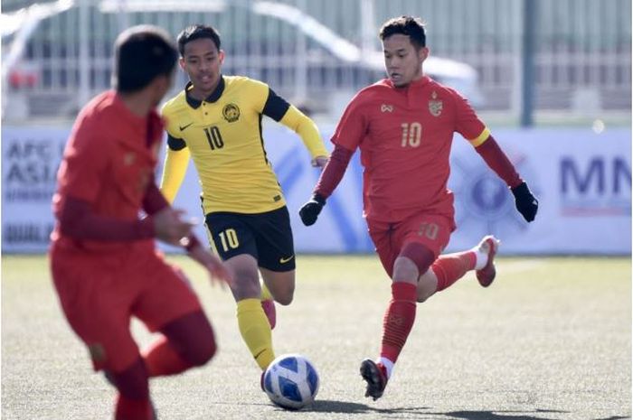 Pemain Timnas U-23 Thailand, Thanawat Suengchitthawon (kanan), sedang menggiring bola dalam pertandingan melawan Malaysia di Kualifikasi Piala Asia U-23 2022.