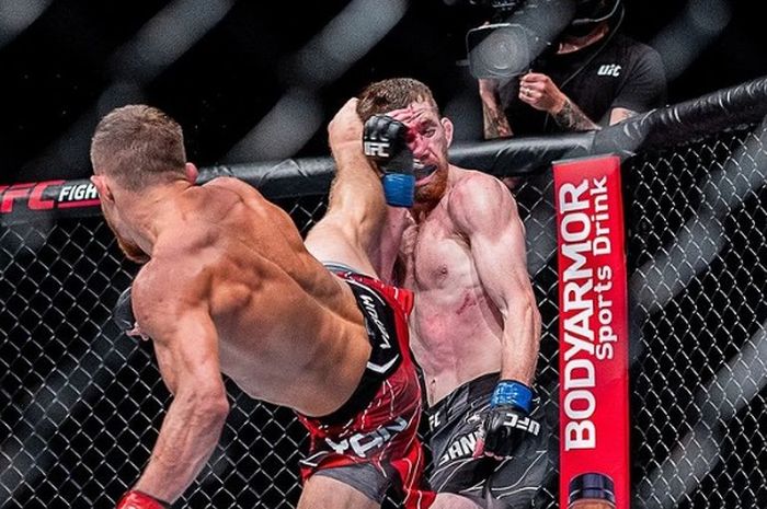 Usaha Cory Sandhagen (kanan) menahan tendangan dari Petr Yan pada UFC 267 (30/10/2021).