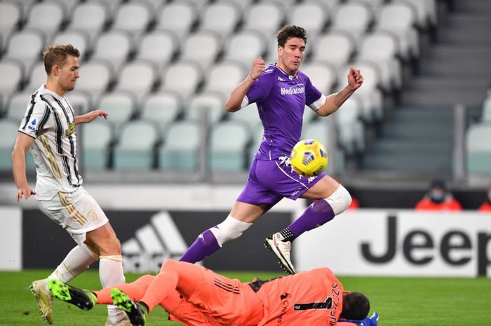 Striker Fiorentina, Dusan Vlahovic, mencoba melewati kiper Juventus, Wojciech Szczesny pada musim 2020-2021.