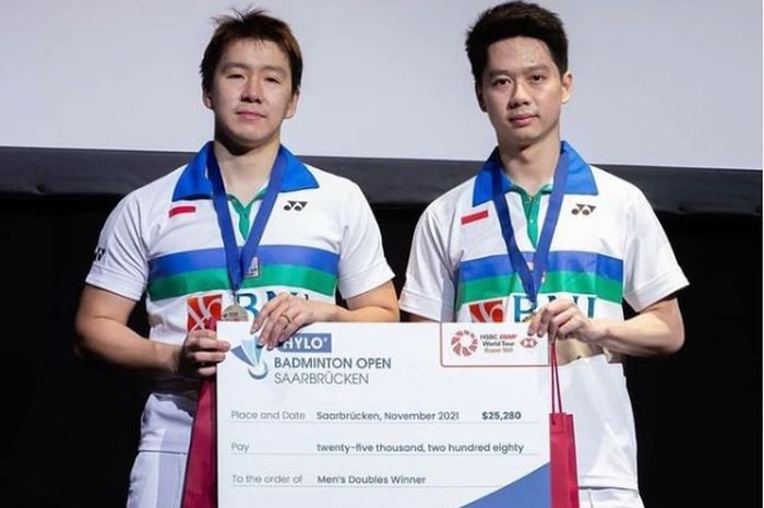 Ganda putra Indonesia, Marcus Fernaldi Gideon/Kevin Sanjaya Sukamuljo berpose di podium saat menjuarai Hylo Open 2021.