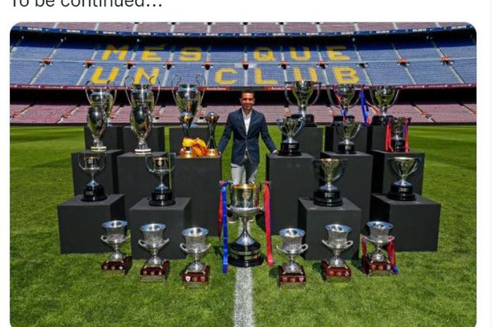 Xavi Hernandez berpose dengan trofi bersama Barcelona.