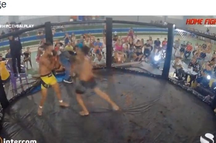 Momen jagoan MMA, Romero Reis (celana hitam) melepaskan serangan yang membuat lawannya Diago Galo (celana kuning) terlempar ke luar arena pada Home Fight Championship di Brazil (4/12/2021).