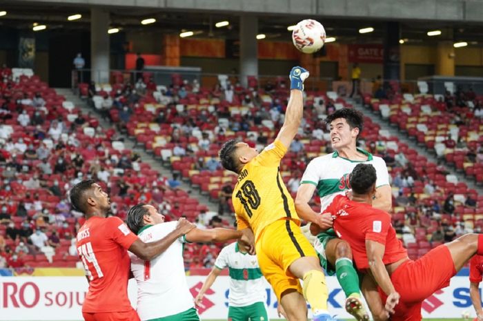 Bek Timnas Indonesia Elkan Baggott (kanan atas) coba menyundul bola dalam semifinal leg pertama Piala AFF 2020 melawan Singapura, Rabu (22/12/2021), di Stadion Nasional, Kallang, Singapura.