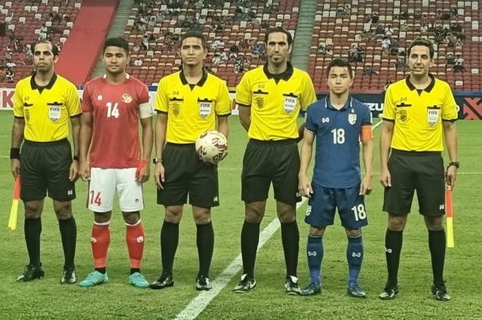 Kapten timnas Indonesia, Asnawi Mangkualam, dan kapten Thailand, Chanathip Songkrasin, berfoto bersama wasit jelang laga leg pertama final Piala AFF 2020.