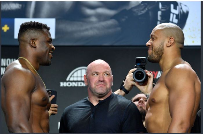 Ketika Francis Ngannou (kiri) dan Ciryl Gane (kanan) melakukan sesi face-off setelah proses penimbangan badan pada Jumat (21/1/2022) waktu setempat. Pertemuan tatap wajah Ngannou dan Gane ditengahi Presiden UFC, Dana White (tengah).