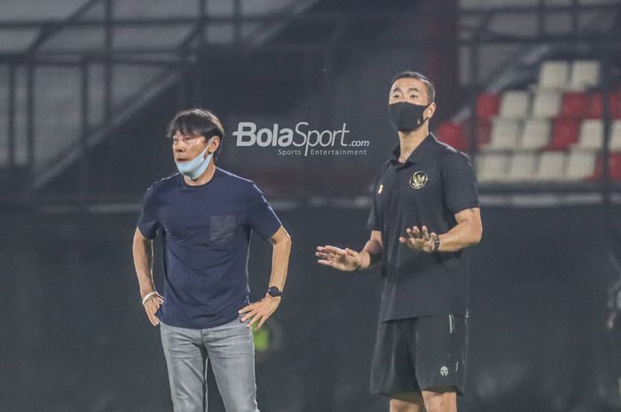 Pelatih timnas Indonesia, Shin Tae-yong (kiri), dan salah satu asistennya yakni Yoo Jae-hoon (kanan), sedang memberikan intruksi kepada para pemainnya  di Stadion Kapten I Wayan Dipta, Gianyar, Bali, 27 Januari 2022.