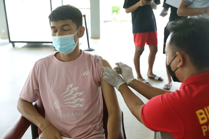 Pebulu tangkis ganda putra Indonesia, Fajar Alfian, saat menjalani vaksin Covid-19 ketiga di pelatnas PBSI, Cipayung, Jakarta, Jumat (4/2/2022).