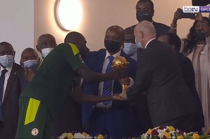 Kapten Senegal, Kalidou Koulibaly saat menerima trofi dari Presiden Kamerun, Paul Biya usai Senegal menjuarai Piala Afrika 2021 di Stade Omnisport Paul Biya, Minggu (6/2/2022) atau Senin dini hari WIB. 