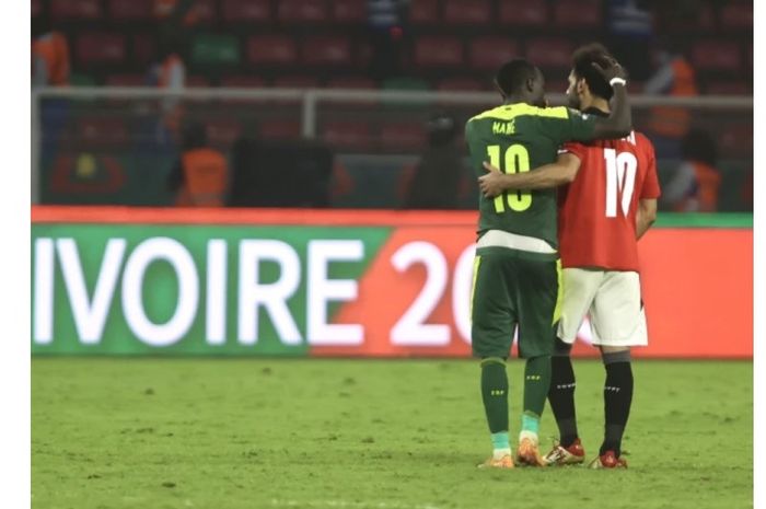 Momen Sadio Mane (kiri) berbicara dengan Mohamed Salah usai final Piala Afrika 2021. 