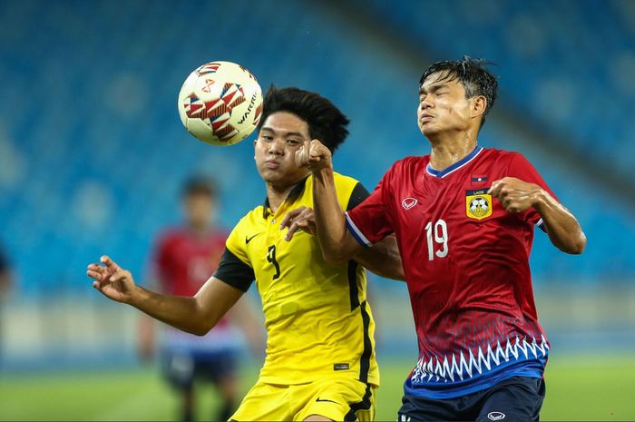 Gelandang Timnas U-23 Malaysia Harith Naem Jaineh (kiri) berebut bola dengan bek Timnas U-23 Laos Nalongsit Chanthalangsy dalam laga Grup B Piala AFF U-23 2022 di Stadion Morodok Techo National, Phnom Penh, Kamboja, Senin (21/2/2022).