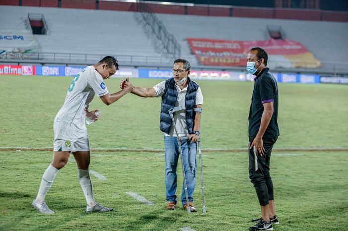 Pelatih Persebaya Surabaya, Aji Santoso, menggunakan alat penyangga kaki saat bertanding melawan Persita Tangerang, Minggu (6/3/2022).