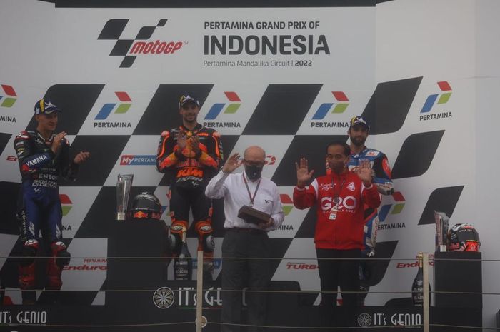 Dari kiri ke kanan (atas) Fabio Quartararo (Monster Energy Yamaha), Miguel Oliveira (KTM Redbull), Johann Zarco (Pramac Racing) bersama CEO Dorna Carmelo Ezpeleta dan Presiden RI Jokowi di podium MotoGP Indonesia 2022 di Sirkuit Mandalika, Lombok, NTB, Minggu (20/3/2022).