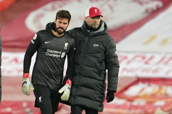 Juergen Klopp (kanan) merangkul Alisson Becker dalam partai Liga Inggris Liverpool vs Burnley di Anfield (21/1/2022).