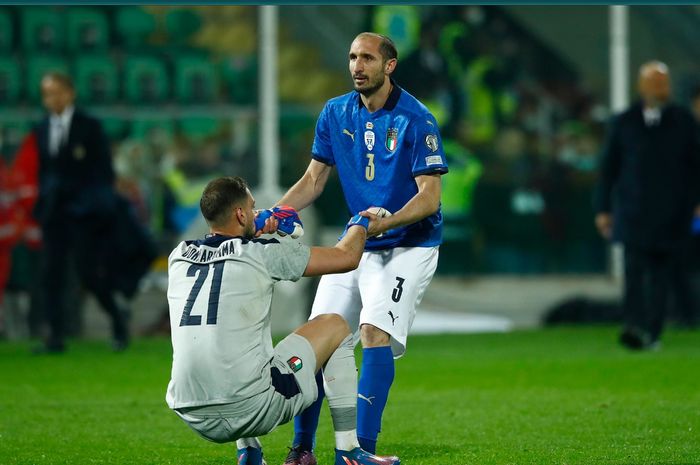 Kiper timnas Italia, Gianluigi Donnarumma tampak berusaha dikuatkan oleh Giorgio Chiellini usai timnya gagal lolos ke Piala Dunia 2022.