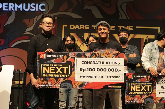 Ronald Steven (kiri) menyerahkan hadiah secara simbolis kepada Juara 1 DTBTNS Season 2 dari kategori musik, yaitu perwakilan personel Mad Elephant.