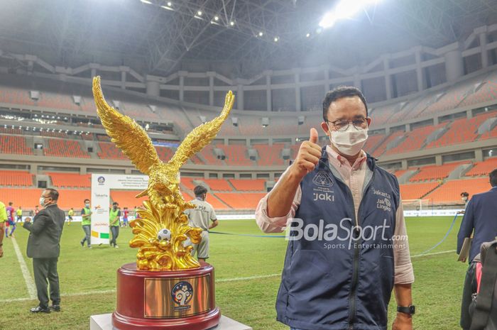 Gubernur DKI Jakarta, Anies Baswedan (kanan), nampak memberikan ancungan jempol di samping piala International Youth Championship (IYC) 2021 di Jakarta Internasional Stadium, Jakarta Utara, 19 April 2022.