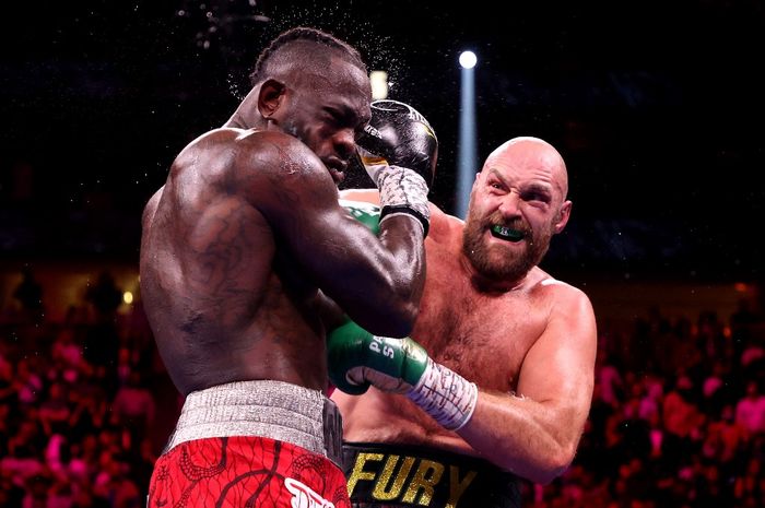 Tyson Fury (kanan) memukul Deontay Wilder dalam pertandingan perebutan gelar juara dunia kelas berat WBC di T-Mobile Arena, Nevadas, Amerika Serikat, 9 Oktober 2021.
