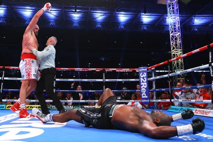 Tyson Fury (kiri) ketika menganvaskan Dillian Whyte (kanan/bawah) pada duel mereka yang berlangsung di Stadion Wembley, London, Inggris, Sabtu (24/4/2022).