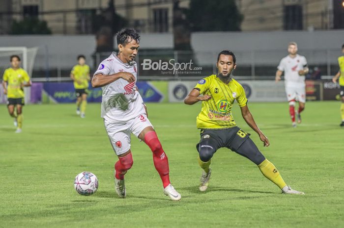 Bek sayap kanan PSM Makassar, Zulkifli Syukur (kiri), sedang menguasai bola dan dibayangi striker Barito Putera, Beni Oktovianto (kanan), dalam laga pekan ke-21 Liga 1 2021 di Stadion Kompyang Sujana, Bali, 28 Januari 2022.