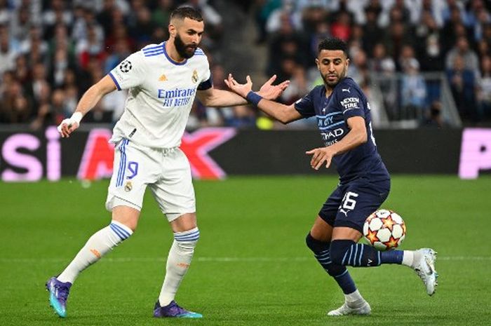 Striker Real Madrid, Karim Benzema, berduel dengan penyerang Manchester City, Riyad Mahrez, dalam laga leg kedua semifinal Liga Champions di Stadion Santiago Bernabeu, Rabu (4/5/2022).