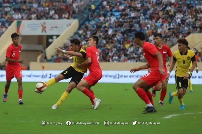 Penyerang Timnas U-23 Malaysia, Hadi Fayyadh, tengah berduel dengan pemain Timnas u-23 Singapura pada laga Grup B SEA Games 2021.