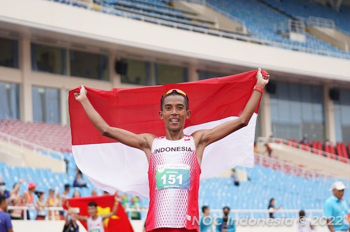 Pelari Indonesia, Agus Prayogo, mengibarkan bendera Merah Putih setelah mendapat medali perak dari lomba marathon putra SEA Games 2021 di My Dinh National Stadium, Hanoi, Vietnam, 19 Mei 2022.