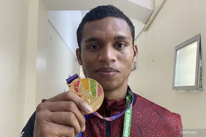 Petinju Indonesia Maikhel Roberrd Muskita menunjukkan medali emas dari ajang SEA Games 2021