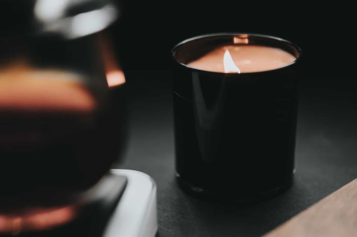 Warga sedang menyalakan lilin aromaterapi di tengah ruangan yang dipenuhi cahaya lembut