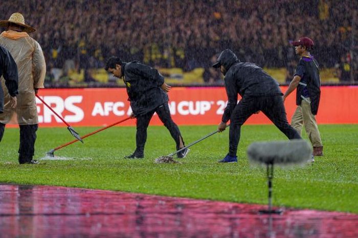 Petugas membuang air yang menggenang di laga Kualifikasi Piala Asia 2023 antara Malaysia melawan Bahrain di Stadium Nasional, Bukit Jalil.