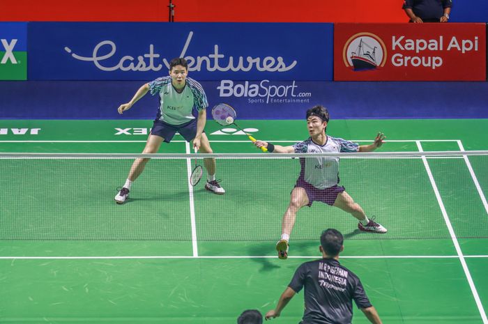 Ganda putra Indonesia, Kang Min-hyuk (memukul kok) dan Seo Seung-jae, saat tampil pada Indonesia Open 2022.