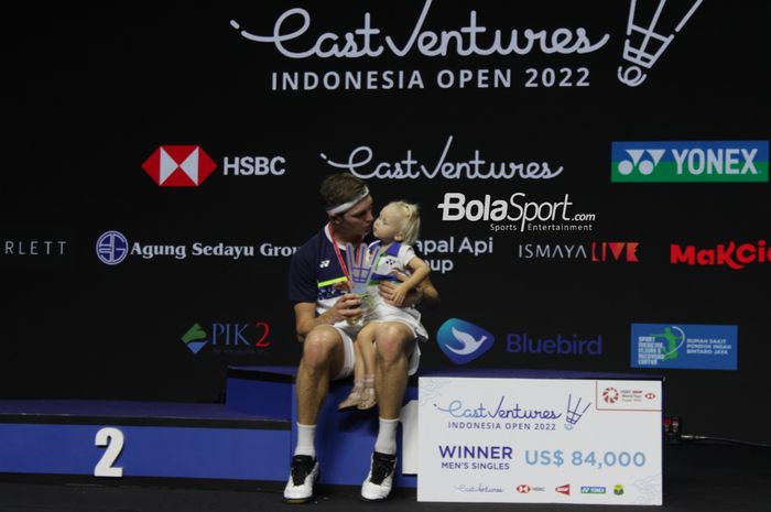 Pebulu tangkis tunggal putra Denmark, Viktor Axelsen yang mencium anaknya  setelah menjuarai Indonesia Open 2022 di Istora Senayan, Jakarta, pada Minggu (19/6/2022).