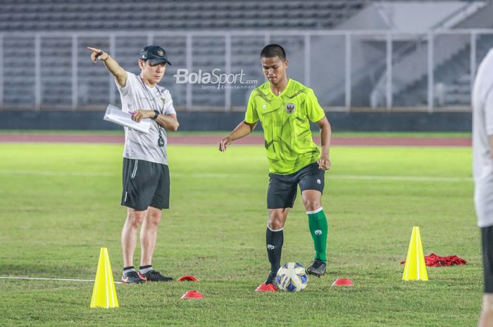 Pelatih timnas U-19 Indonesia, Shin Tae-yong (kiri), sedang memberikan intruksi ke pemainnya yang bernama Radzky Syahwal Ginting (kanan) dalam latihannya di Stadion Madya, Senayan, Jakarta, 21 Juni 2022.