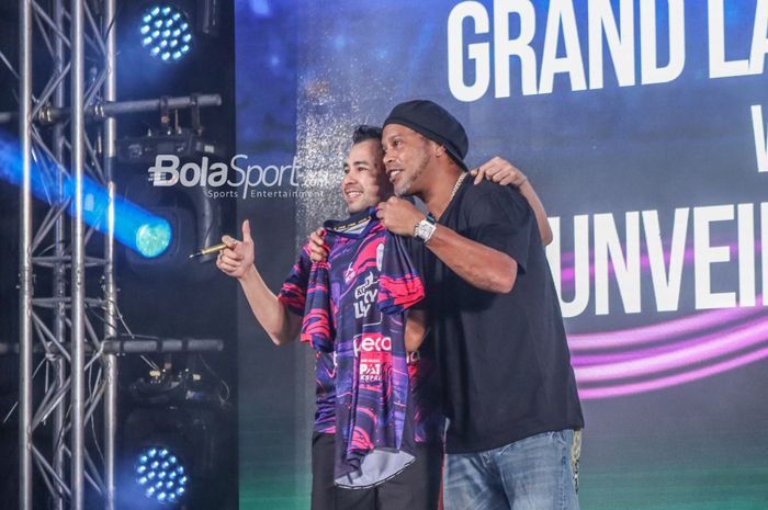 Ronaldinho (kanan) sedang memegangi jersey baru RANS Nusantara FC ditemani oleh Raffi Ahmad (kiri) selaku chairman tim di Menara Mandiri, Senayan, Jakarta, 24 Juni 2022.