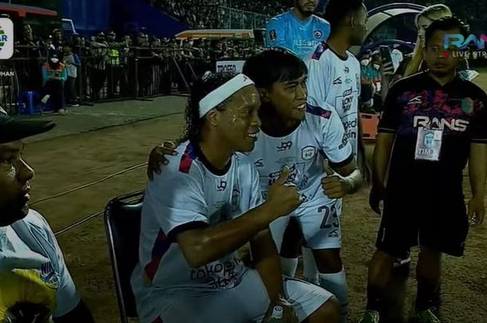 Ronaldinho melayani permintaan foto dari pemain Rans Nusantara FC pada laga segitiga kontra Arema FC dan Persik Kediri (26/6/2022). 