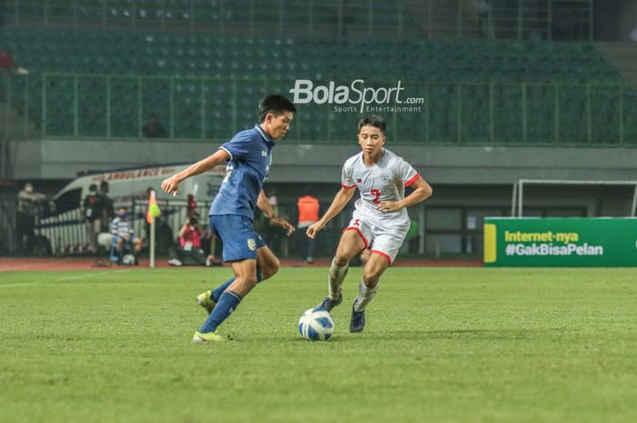 Pemain timnas U-19 Thailand, Pornsawan Kansia (kiri), sedang berebut bola dengan pilar timnas U-19 Filipina bernama Zachary C. Taningco (kanan) 