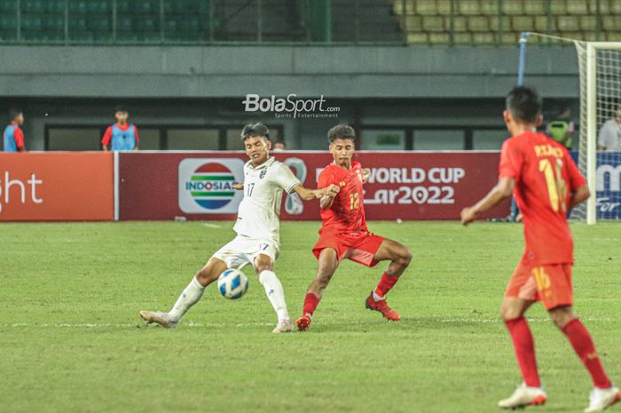 Pemain timnas U-19 Thailand, Thanawut Phochai (kiri), sedang menguasai bola dan dibayangi pilar timnas U-19 Myanmar bernama Tun Tun Thein (kanan) di Stadion Patriot Candrabhaga, Bekasi, Jawa Barat, 4 Juli 2022.
