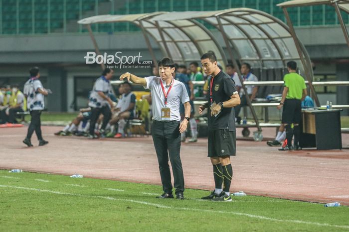 Pelatih timnas U-19 Indonesia, Shin Tae-yong (kiri), sedang memberikan intruksi kepada para pemainnya dan ditemani salah satu asistennya bernama Yoo Jae-hoon (kanan) Penyerang timnas U-19 Indonesia, Razza Fachrezi Aziz (kiri), sedang menguasai bola dan dibayangi pilar timnas U-19 Brunei Darussalam b