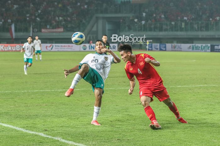 Pemain timnas U-19 Indonesia, Razzaa Fachrezi Aziz (kiri), nampak akan menendang bola dan berusaha dihalau pilar timnas U-19 Vietnam bernama Vu Van Son (kanan) di Stadion Patriot Candrabhaga, Bekasi, Jawa Barat, 2 Juli 2022.