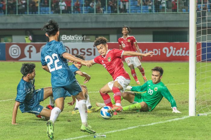 Pemain timnas U-19 Indonesia, Mikael Alfredo Tata (jersey merah), sedang berusaha mencetak gol ke gawang lawan ketika bertanding Gelandang timnas U-19 Indonesia, Arkhan Fikri (kiri), sedang menguasai bola ketika bertanding  di Stadion Patriot Candrabhaga, Bekasi, Jawa Barat, 4 Juli 2022.