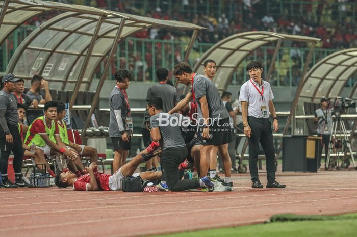 Pelatih timnas U-19 Indonesia, Shin Tae-yong, nampak sedang memantau pemainnya yang bernama Alfriyanto Nico sempat mengalami kram saat bertanding Pemain sayap kanan timnas U-19 Indonesia, Alfriyanto Nico, nampak sedang ditandu keluar lapangan saat mengalami masalah kram saat bertanding di Stadion Pa