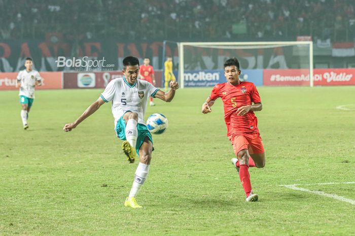 Bek timnas U-19 Indonesia, Kakang Rudianto (kiri), sedang berusaha menendang bola dan dibayangi pilar timnas U-19 Myanmar bernama Lin Lin Tun (kanan) di Stadion Patriot Candrabhaga, Bekasi, Jawa Barat, 10 Juli 2022.