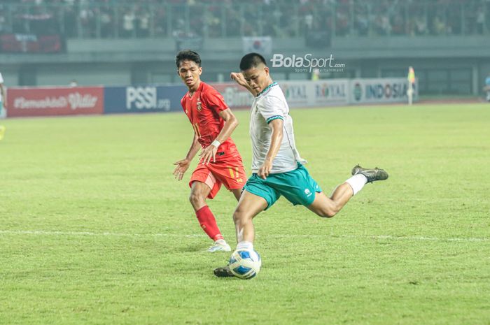 Pemain timnas U-19 Indonesia, Hokky Caraka Bintang Brilliant (kanan), nampak sedang menendang bola dan dibayangi pilar timnas U-19 Myanmar bernama Hein Zaw Naing (kiri) di Stadion Patriot Candrabhaga, Bekasi, Jawa Barat, 10 Juli 2022.