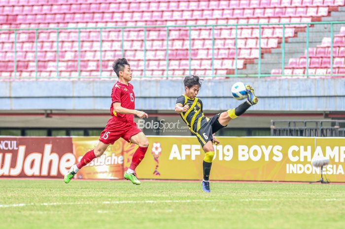 Pemain timnas U-19 Malaysia, Muhammad Alif Farhan Fauzi (kanan), sedang menghalau bola dan dibayangi pilar timnas U-19 Vietnam bernama Nguyen Dinh Bac (kiri) saat bertanding di Stadion Patriot Candrabhaga, Bekasi, Jawa Barat, 13 Juli 2022.