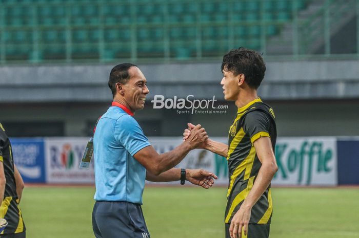 Pelatih timnas U-19 Malaysia, Hassan Sazali Mohd Waras (kiri), sedang bersalaman dengan salah satu pemainnya sebagai bentuk apresiasi ketika bertanding di Stadion Patriot Candrabhaga, Bekasi, Jawa Barat, 13 Juli 2022.