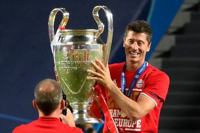 Robert Lewandowski berpose dengan trofi Liga Champions usai Bayern Muenchen kalahkan PSG pada final di Lisabon (23/8/2020).