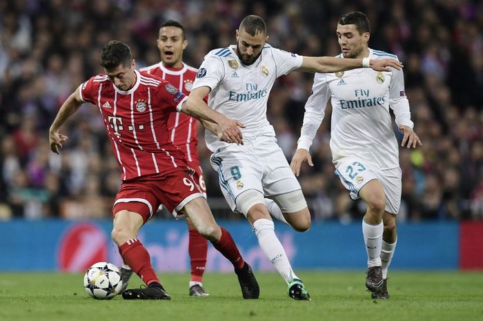 Robert Lewandowski (kiri) mempertahankan bola dari Karim Benzema dalam duel Liga Champions antara Real Madrid vs Bayern Muenchen di Santiago Bernabeu (1/5/2018).
