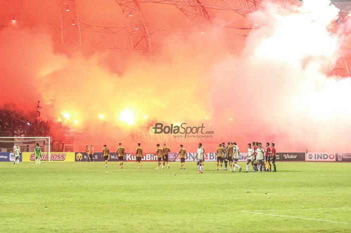 Suporter nampak menyalakan flare atau suar atau petasan seusai laga Bhayangkara FC kontra Persib Bandung di Stadion Wibawa Mukti, Cikarang, Jawa Barat, 24 Juli 2022.